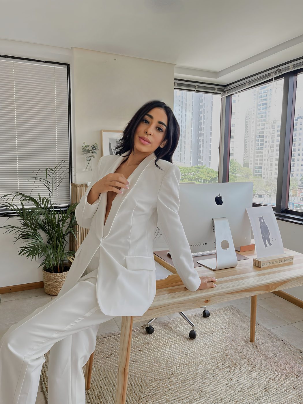 Thaís Rosa apoiada na mesa de trabalho