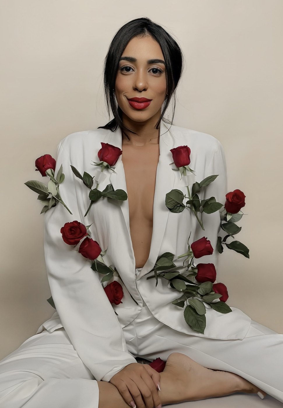 Thaís Rosa de terno branco coberto de rosas vermelhas
